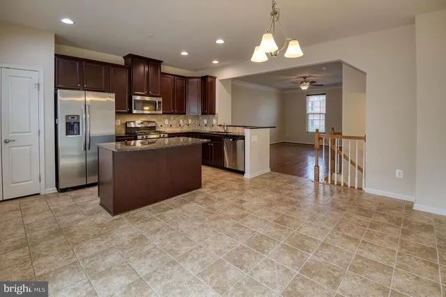 a kitchen with stainless steel appliances granite countertop a stove refrigerator sink and dishwasher