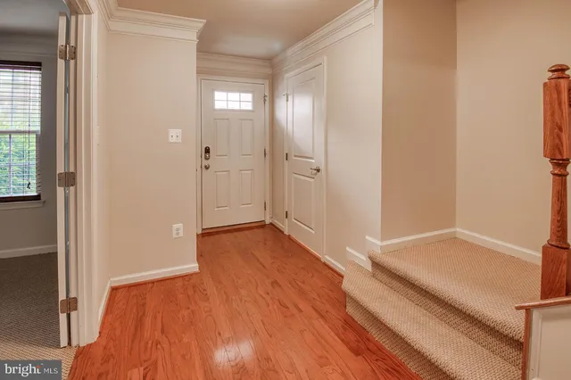 a view of a hallway with wooden floor and a bathroom