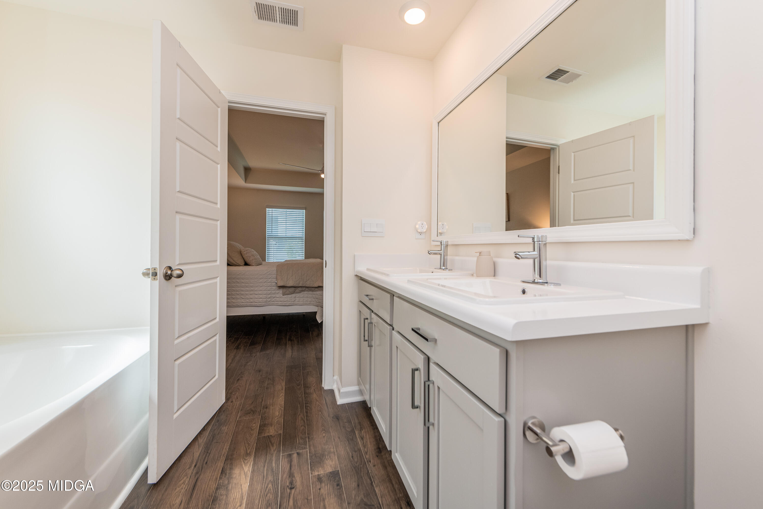 126 Farmers Way Perry, GA 31069 - Photo 16 of 33 a bathroom with a double vanity sink a mirror and a bathtub