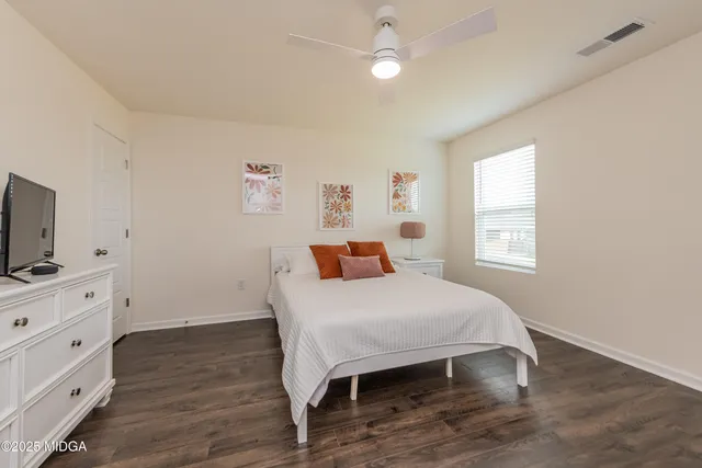 a bedroom with a bed and a flat screen tv