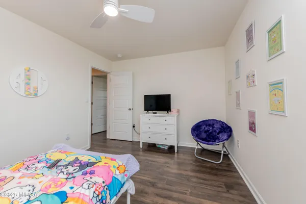 a bedroom with a bed a flat screen tv and a chandelier