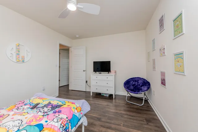 a bedroom with a bed a flat screen tv and a chandelier