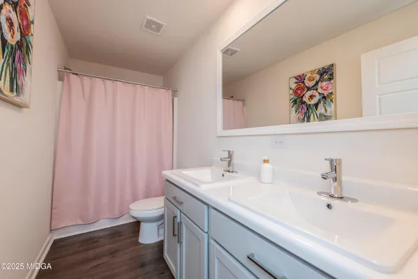 a bathroom with a sink a toilet and shower curtain
