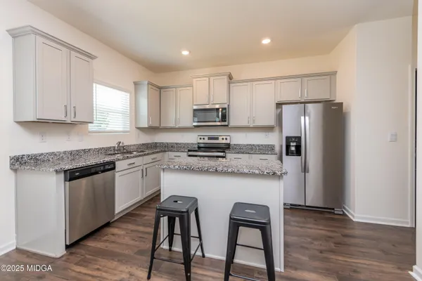 a kitchen with stainless steel appliances granite countertop a stove a refrigerator and a microwave