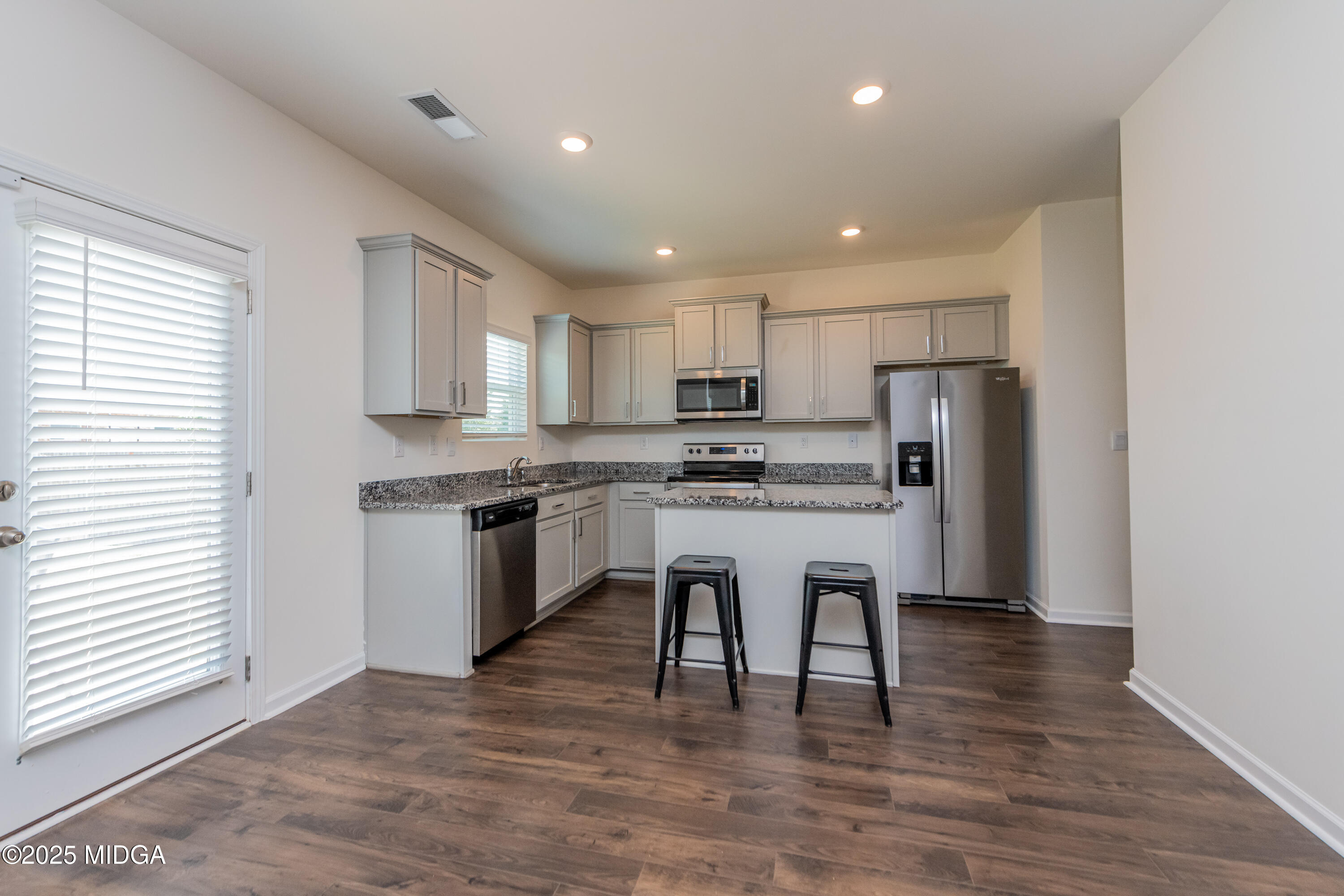 126 Farmers Way Perry, GA 31069 - Photo 6 of 33 a kitchen with stainless steel appliances granite countertop a refrigerator a stove top oven and white cabinets