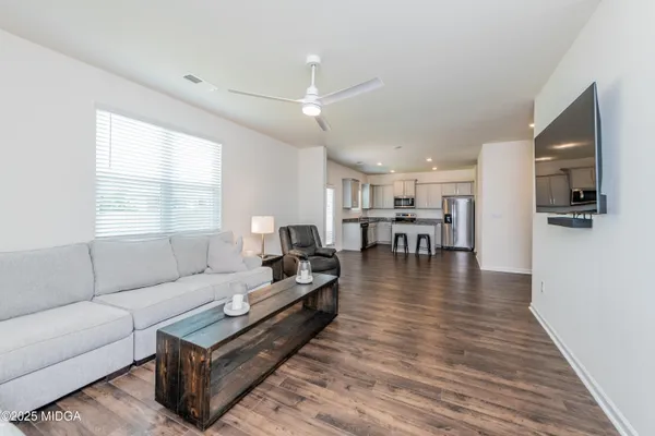 a living room with furniture and a wooden floor