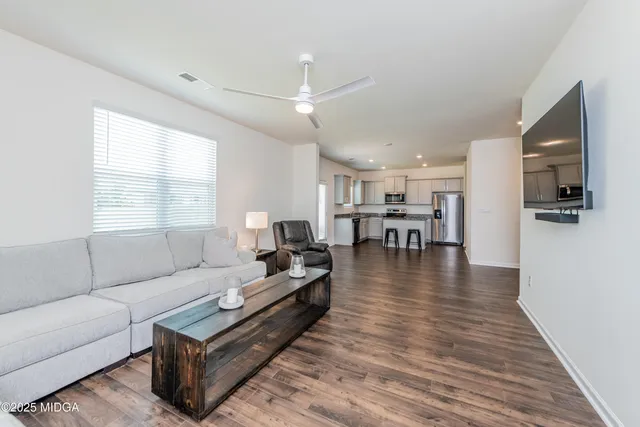a living room with furniture and a wooden floor