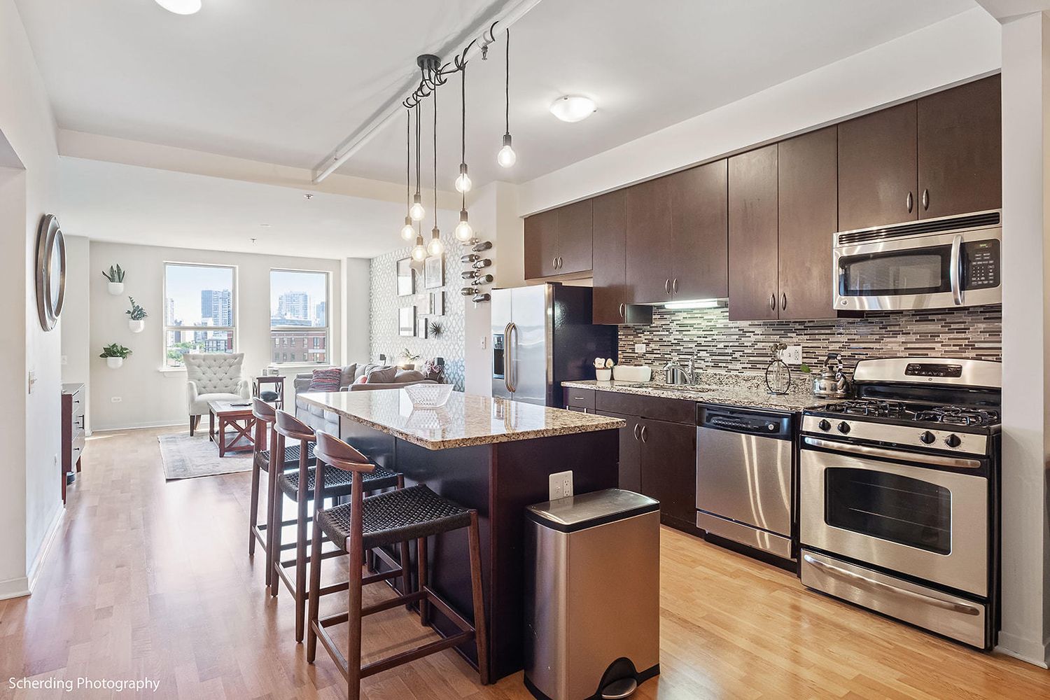 437 West Division Street, Unit 806 Chicago, IL 60610 - Photo 3 of 18 a kitchen with stainless steel appliances wooden floor dining table and chairs