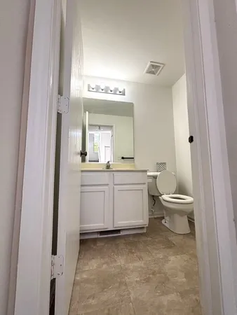 a bathroom with a toilet a sink and a mirror