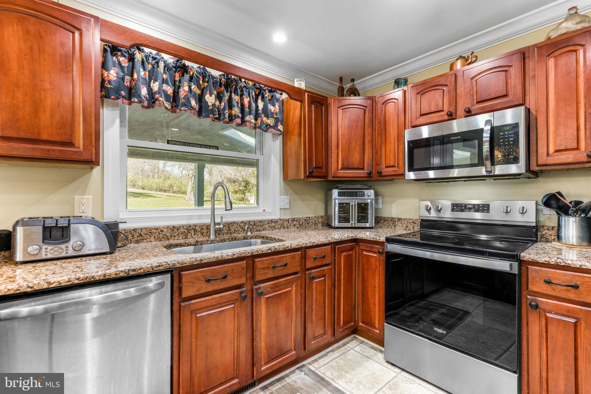 21310 West Liberty Road Parkton, MD 21120 - Photo 33 of 111 a kitchen with granite countertop a sink stove top oven and cabinets