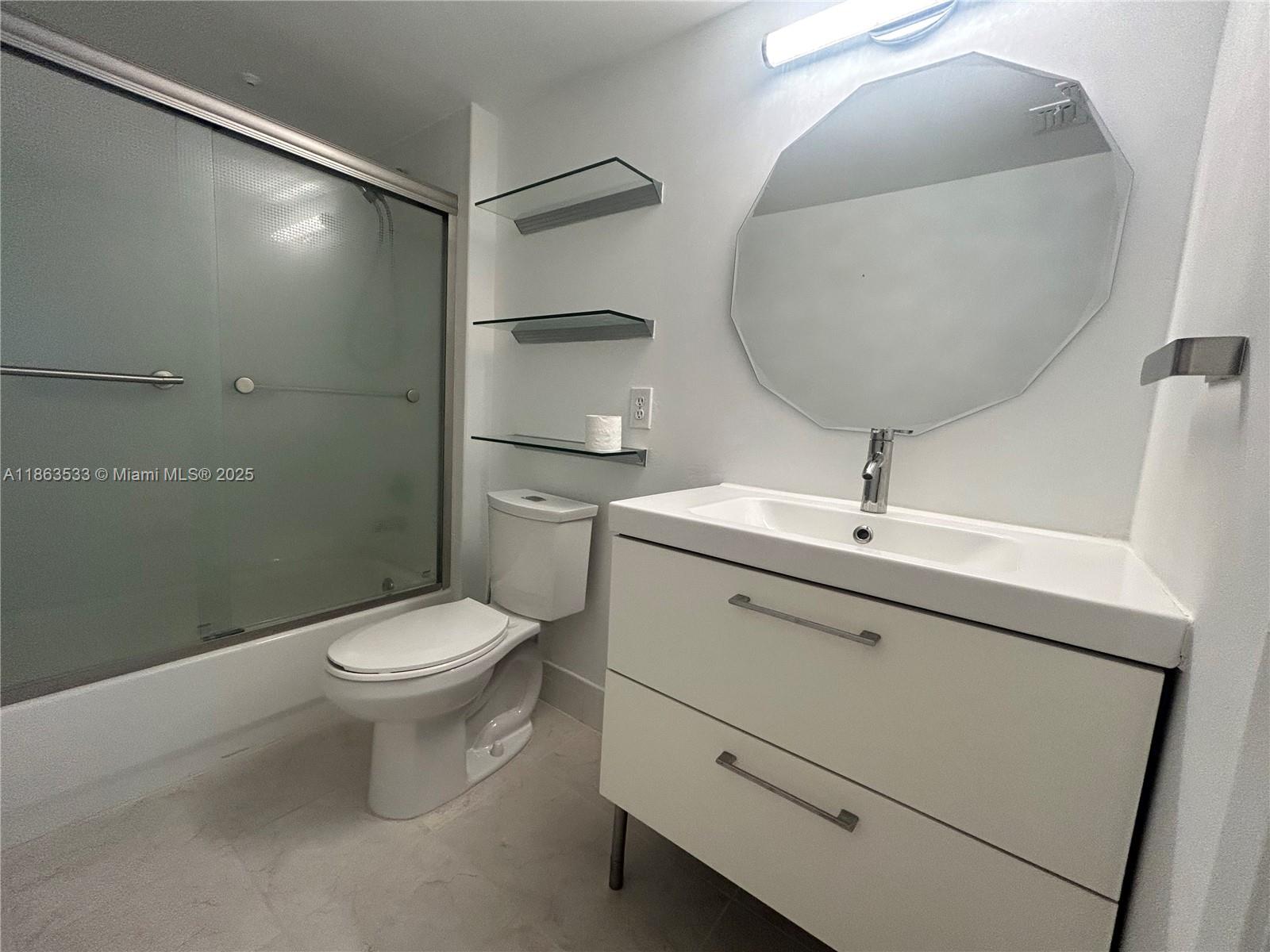 901 Southwest 141st Avenue, Unit 409M Pembroke Pines, FL 33027 - Photo 3 of 10 a bathroom with a toilet sink and mirror
