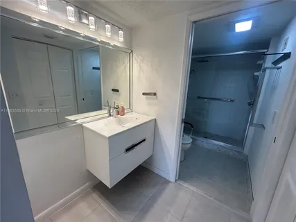 a bathroom with a sink mirror and a shower