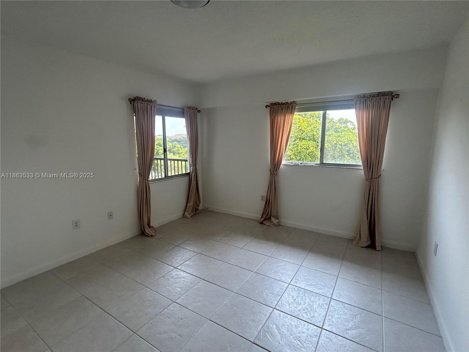 901 Southwest 141st Avenue, Unit 409M Pembroke Pines, FL 33027 - Photo 7 of 10 an empty room with windows
