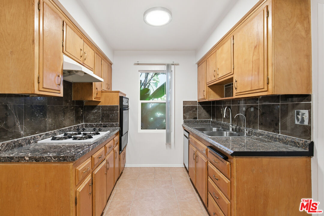 1434 25th Street, Unit 2 Santa Monica, CA 90404 - Photo 8 of 26 a kitchen with stainless steel appliances granite countertop a sink stove and refrigerator