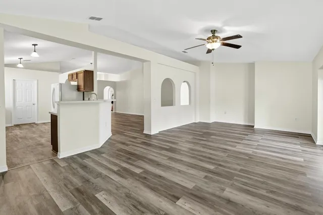 an empty room with a window and a fan