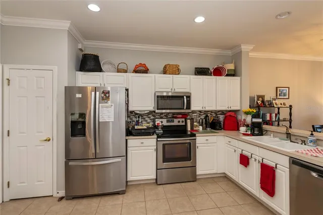 a kitchen with stainless steel appliances a white stove top oven a sink dishwasher and a refrigerator