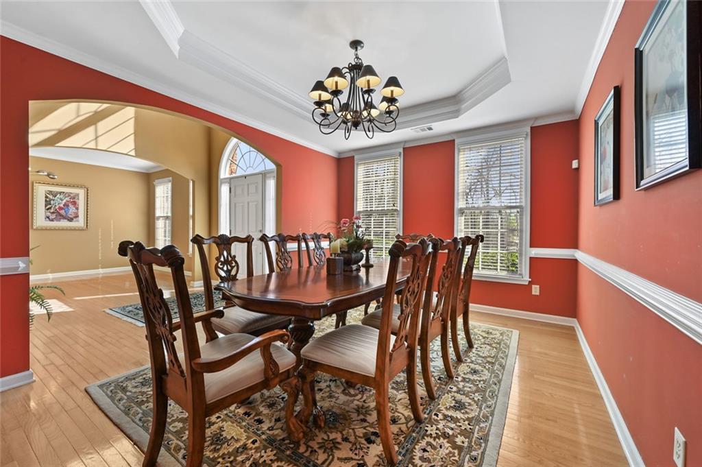 3945 Summit Gate Drive Suwanee, GA 30024 - Photo 15 of 45 a dining room with furniture a chandelier and wooden floor