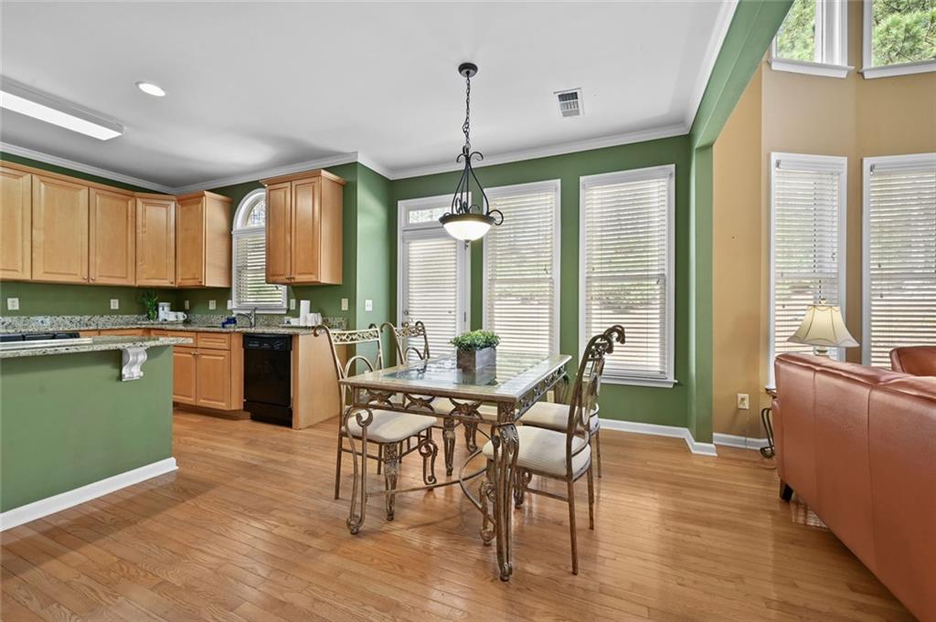 3945 Summit Gate Drive Suwanee, GA 30024 - Photo 21 of 45 a kitchen with kitchen island granite countertop a stove a sink a dining table and chairs