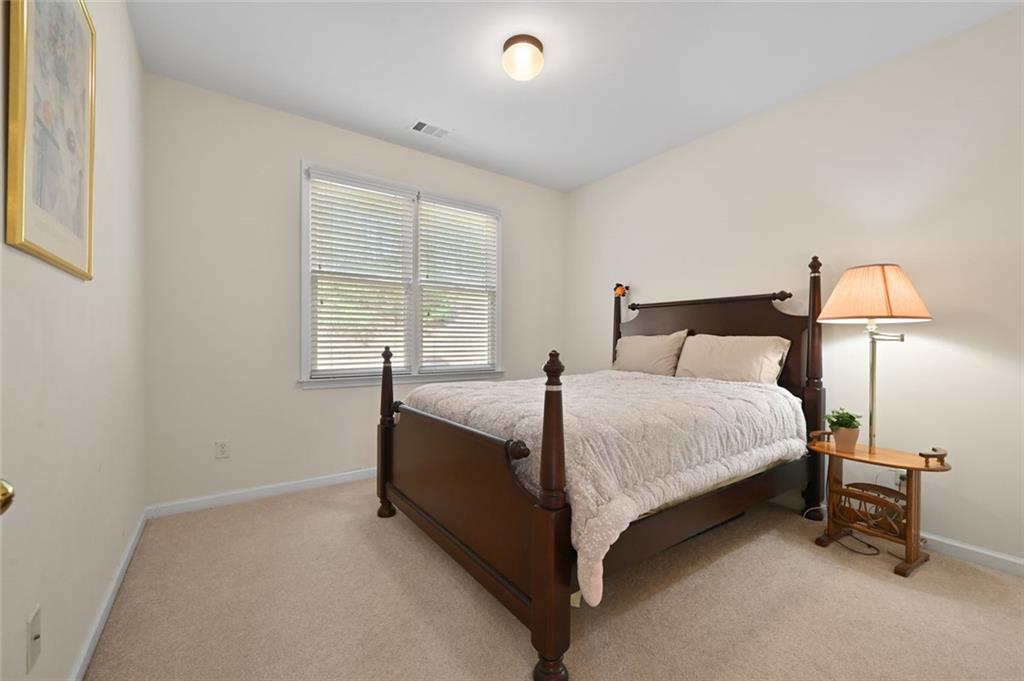 3945 Summit Gate Drive Suwanee, GA 30024 - Photo 26 of 45 a bedroom with a bed and a lamp next to a window