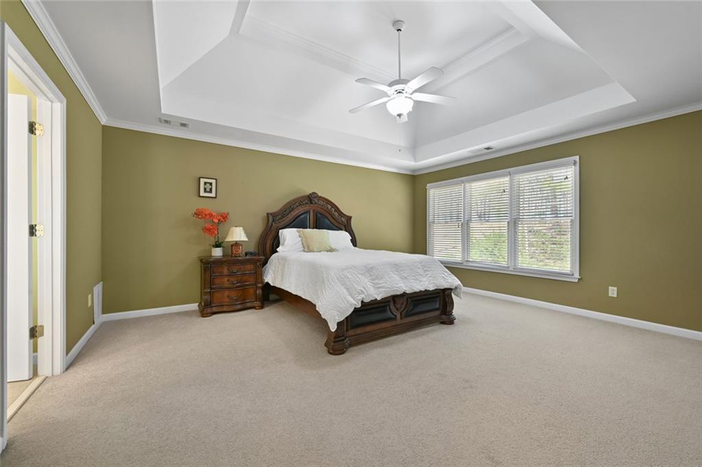 3945 Summit Gate Drive Suwanee, GA 30024 - Photo 30 of 45 a bedroom with a bed and a chandelier
