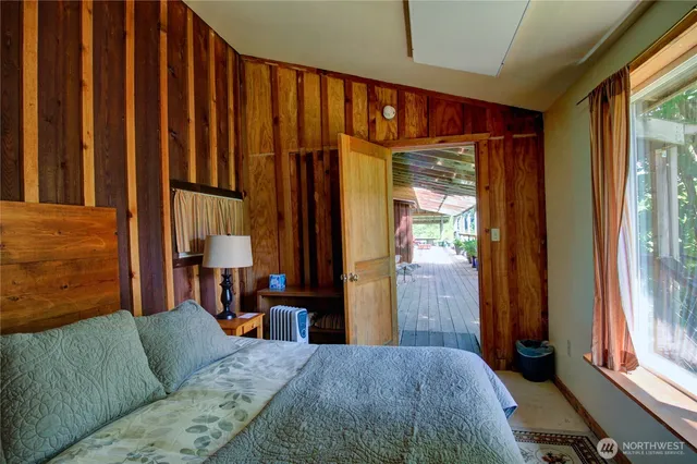 a bedroom with a bed and a dresser next to a window