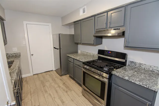 a kitchen with granite countertop a stove and a refrigerator