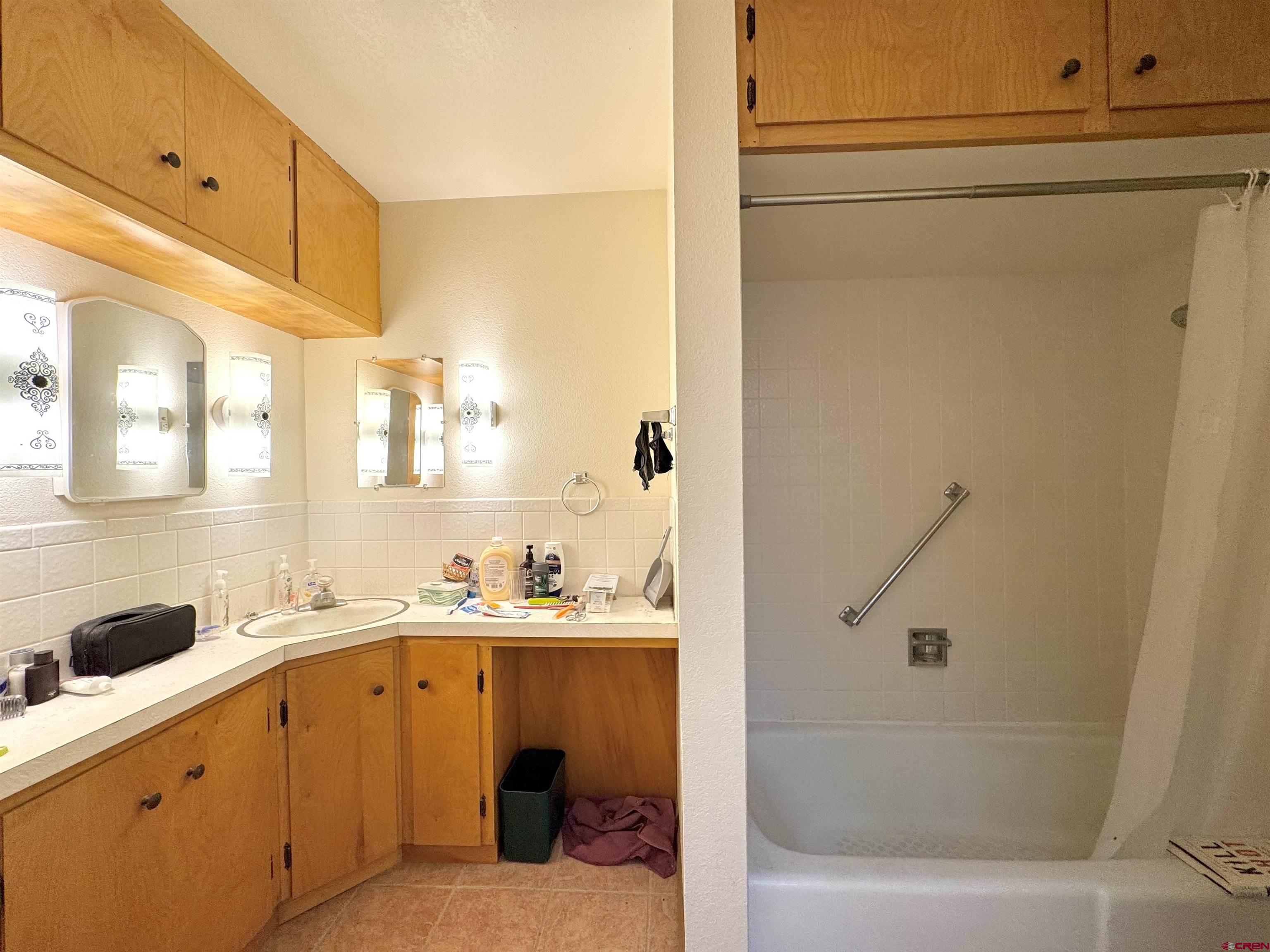 631 2nd Street Alamosa, CO 81101 - Photo 17 of 30 a bathroom with a tub sink and mirror