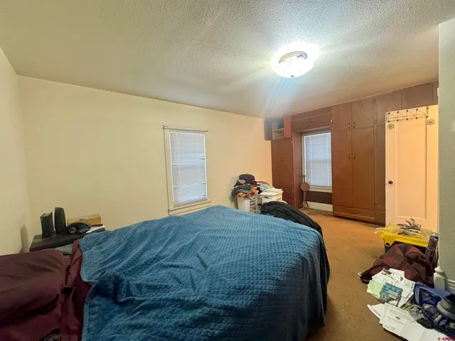 a bed sitting in a spacious bedroom next to a window