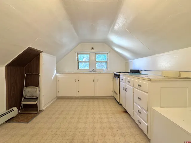 a large white kitchen with cabinets