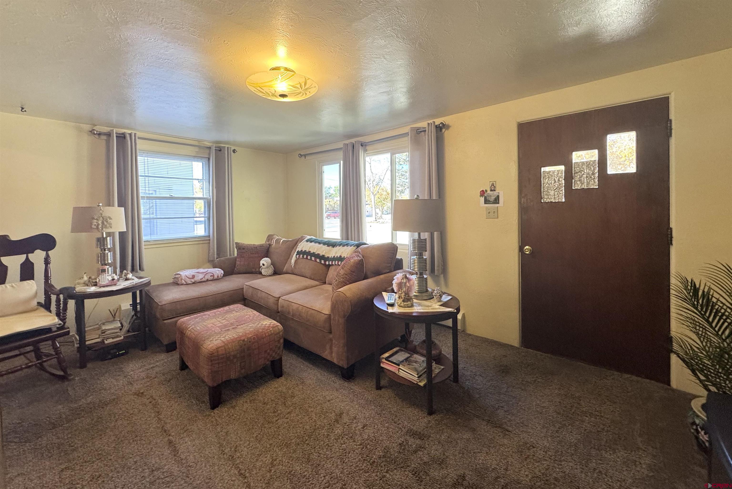 631 2nd Street Alamosa, CO 81101 - Photo 6 of 30 a living room with furniture and a chandelier