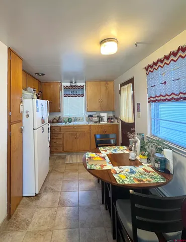 a kitchen with a table chairs and refrigerator