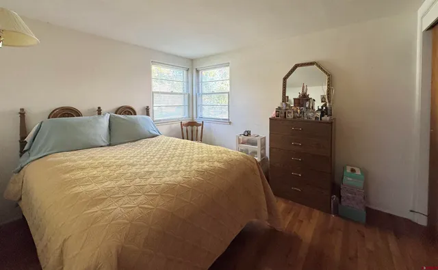 a bed sitting in a bedroom next to a window with dresser