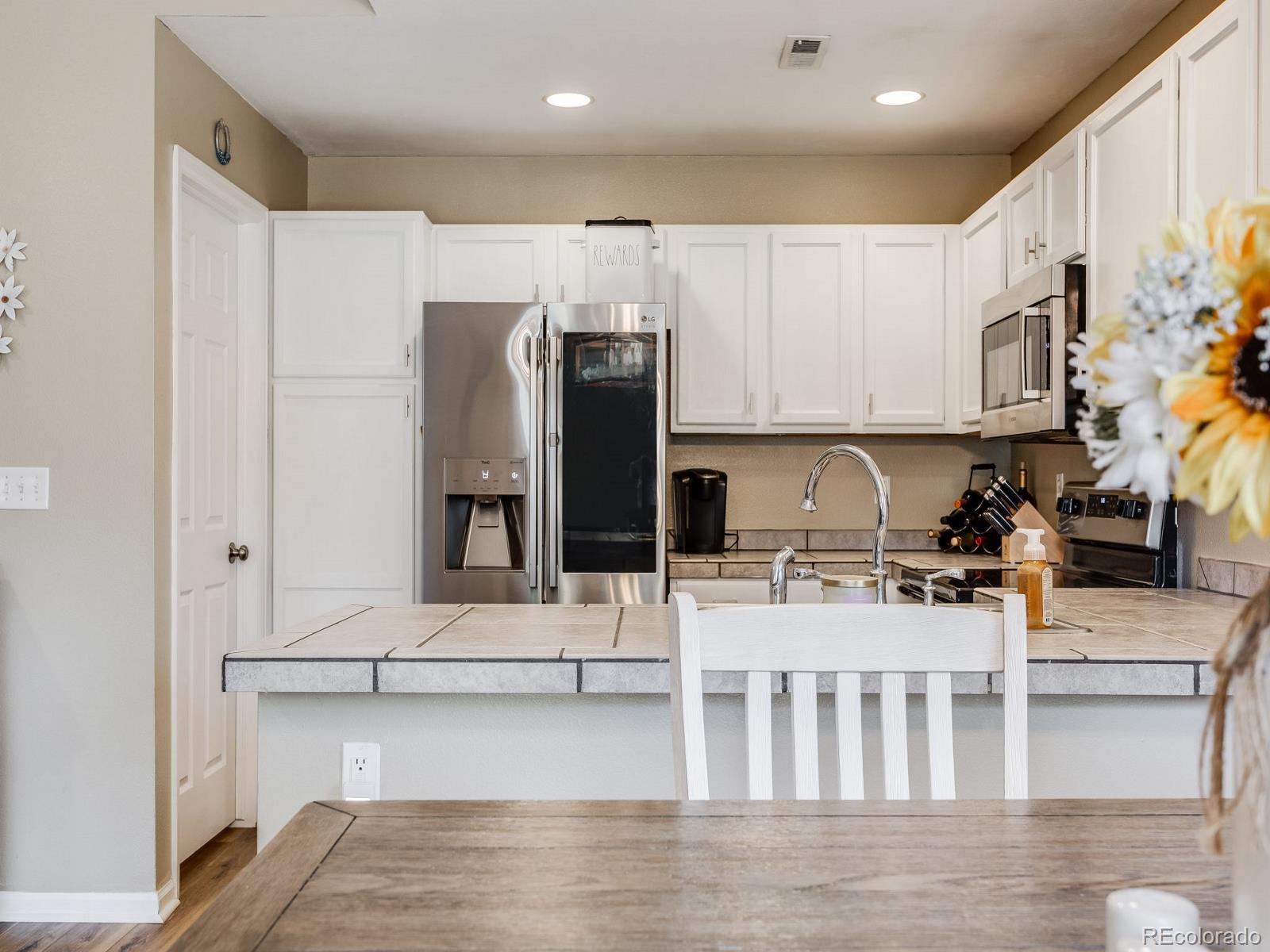6360 Viewpoint Avenue Firestone, CO 80504 - Photo 14 of 27 a kitchen with stainless steel appliances kitchen island granite countertop a refrigerator and a stove top oven