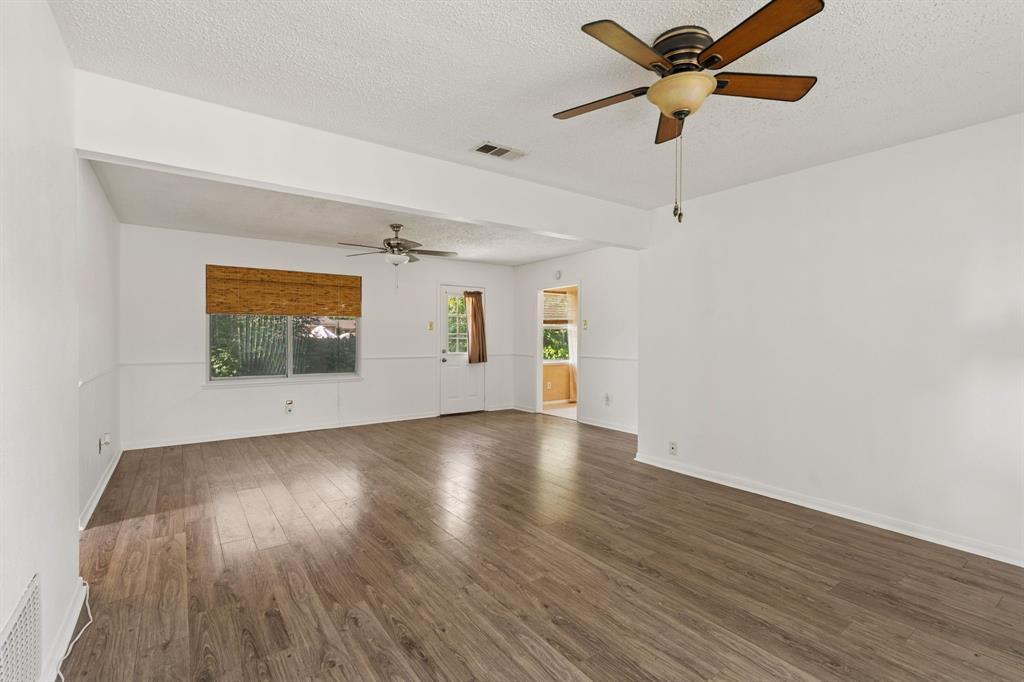 1822 Finley Road Irving, TX 75062 - Photo 11 of 38 an empty room with wooden floor chandelier fan and windows