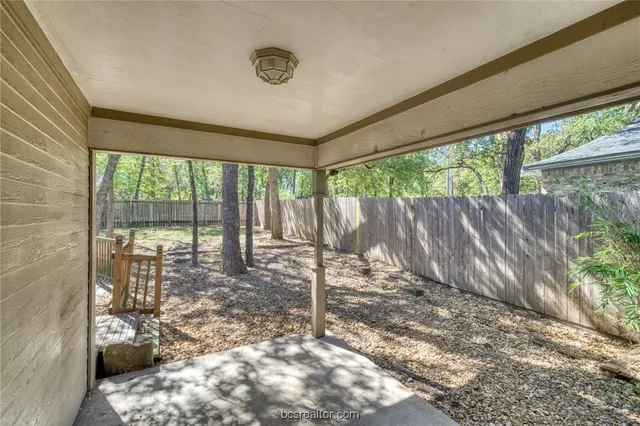 a view of a brick house with large trees and stairs