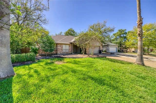 a view of a house with a big yard and potted plants
