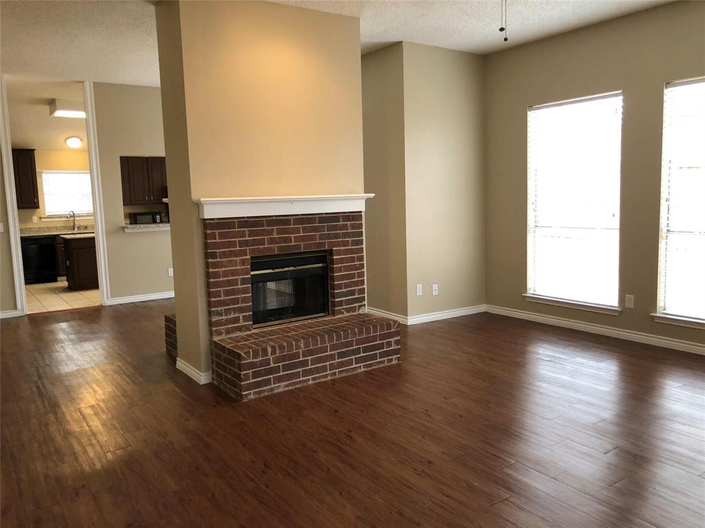 8301 Bells Street Frisco, TX 75035 - Photo 5 of 24 an empty room with wooden floor fireplace and windows
