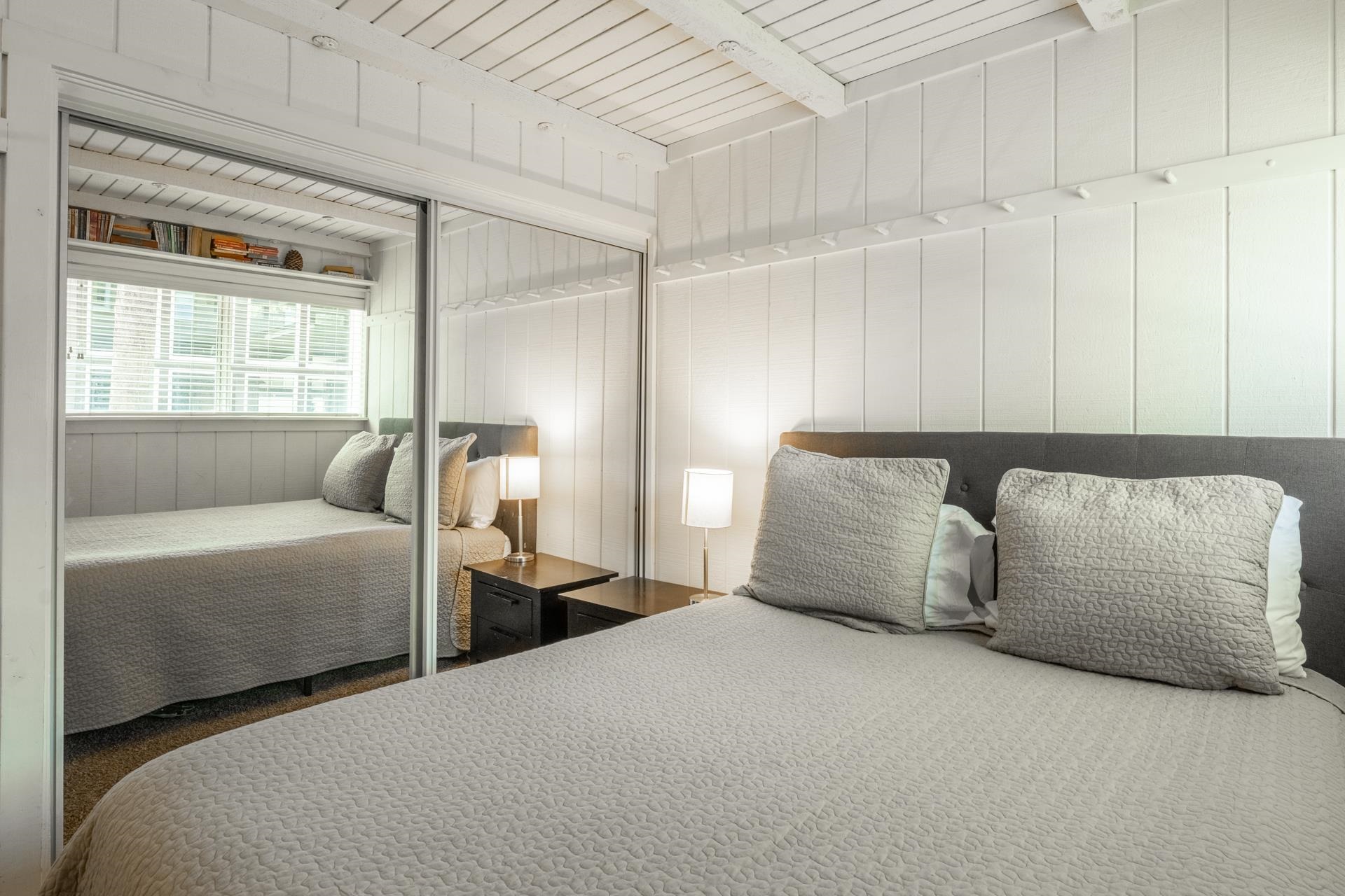 165 Old Mammoth Road, Unit 3 Mammoth Lakes, CA 93546 - Photo 29 of 48 Room featuring white vertical plank walls, a matching white plank ceiling with exposed beams, and mirrored sliding closet doors