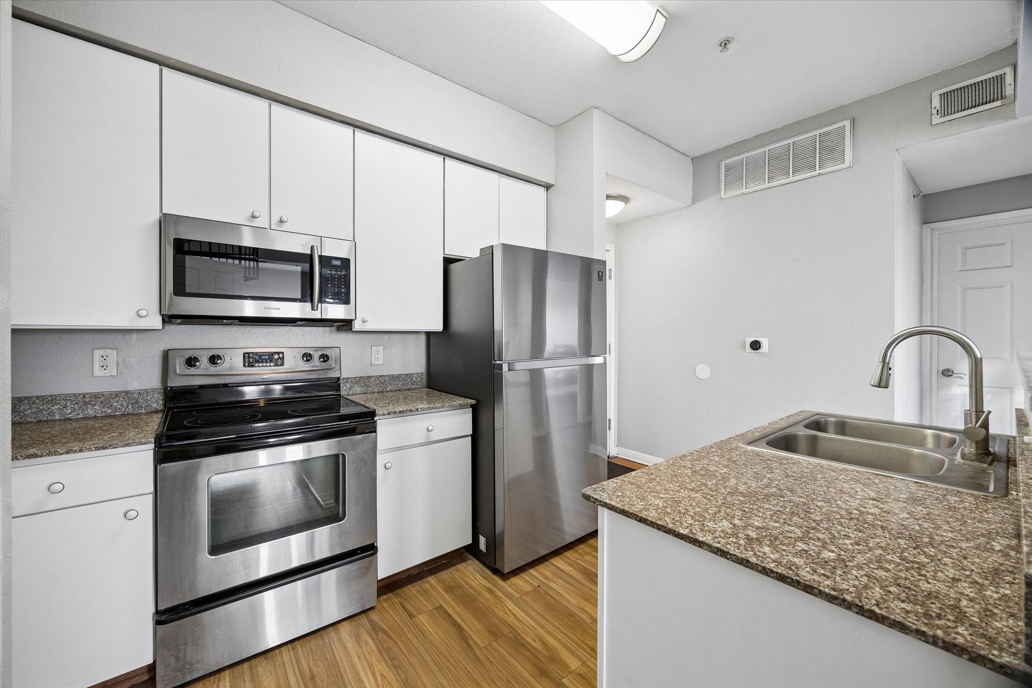 2502 Leon Street, Unit 506 Austin, TX 78705 - Photo 8 of 15 a kitchen with stainless steel appliances granite countertop a stove a refrigerator and a sink