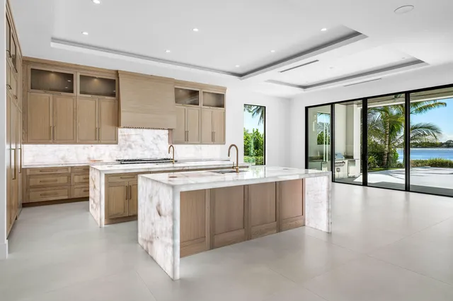 a bathroom with a granite countertop sink mirror and window