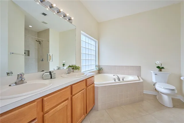 a spacious bathroom with a double vanity sink mirror and bathtub