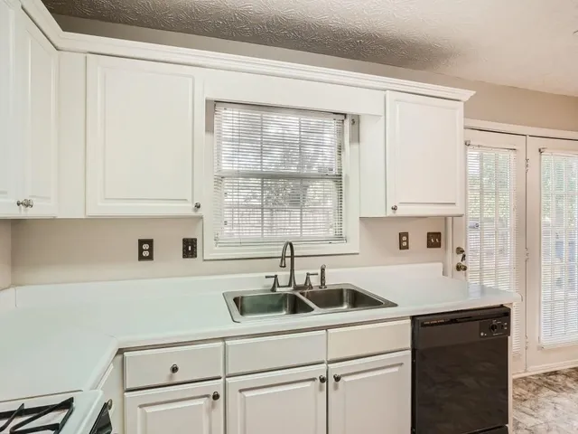 a kitchen with a sink cabinets and window