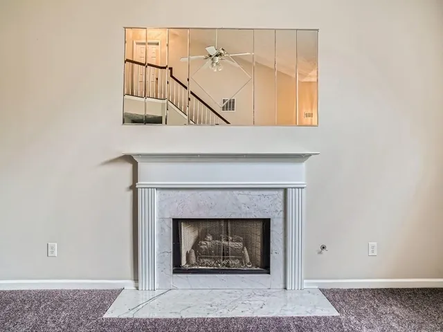 a living room with a fireplace and a rug