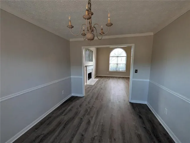 a view of a room with wooden floors and chandelier