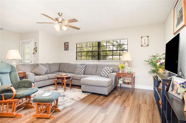a living room with furniture a flat screen tv and a window