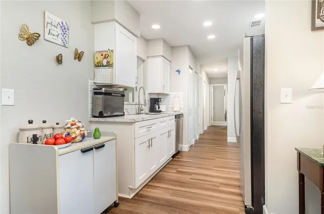 a kitchen with white cabinets and chandelier