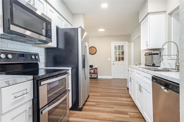 a kitchen with stainless steel appliances granite countertop a stove and a refrigerator