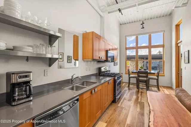 a kitchen with stainless steel appliances granite countertop a sink and wooden cabinets