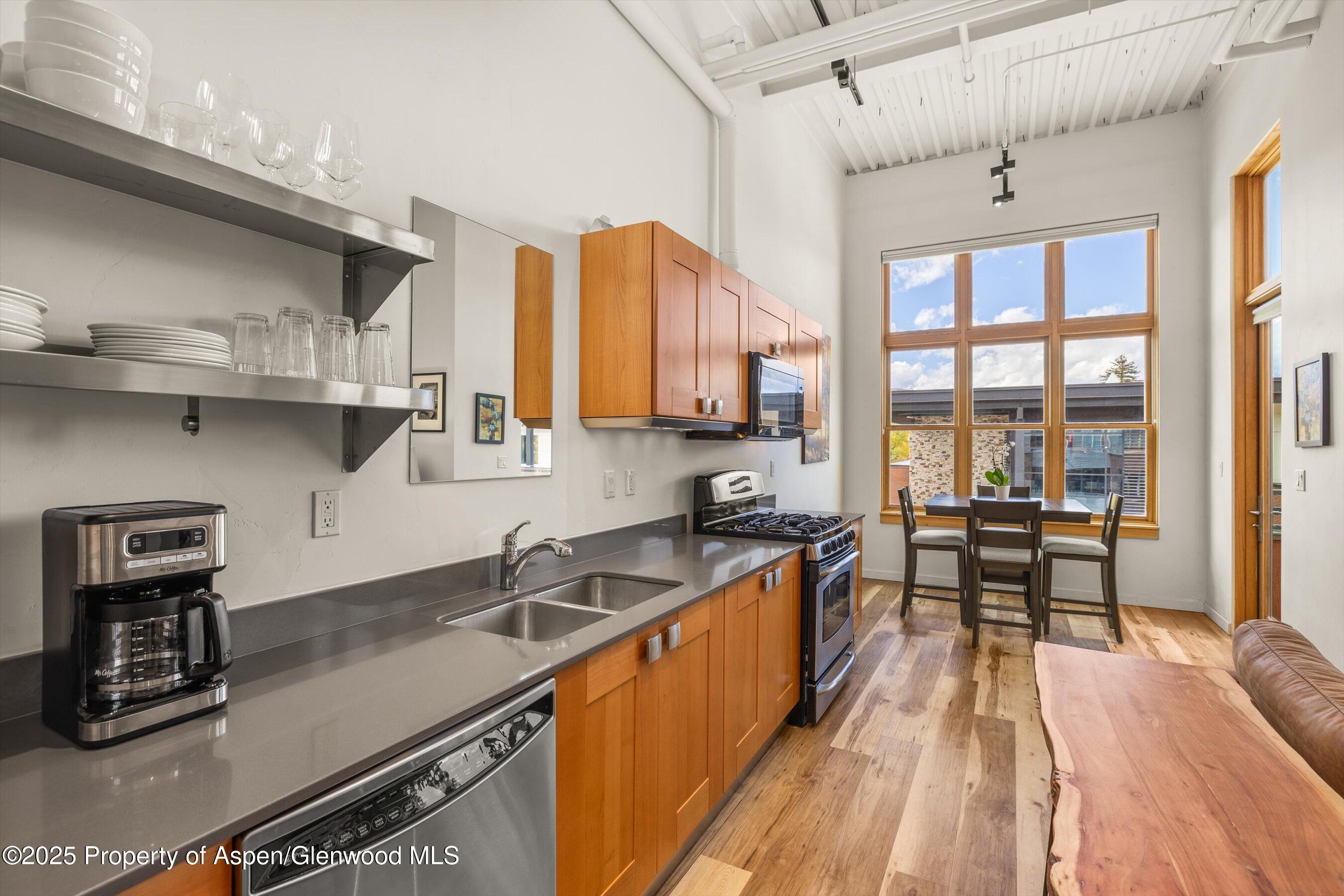 231 Robinson Street, Unit 302 Basalt, CO 81621 - Photo 7 of 17 a kitchen with stainless steel appliances granite countertop a sink and wooden cabinets