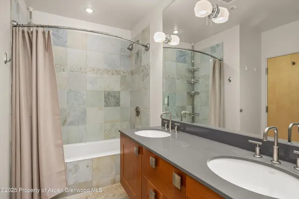 a bathroom with a granite countertop sink mirror and a bath tub